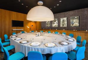 a conference room with a large table and blue chairs at Dream Downtown, by Hyatt in New York +136 photos