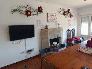 a living room with a table and a television on the wall at Chalet Lanzada in Sanxenxo