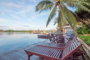 a couple of chairs sitting on a dock next to the water at Villa Republic River View Bentota in Aluthgama