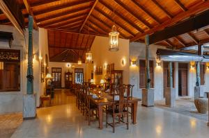a dining room with a long table and chairs at Villa Republic River View Bentota in Aluthgama