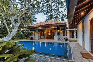 a swimming pool in front of a house at Villa Republic River View Bentota in Aluthgama