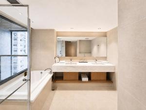 a bathroom with a sink and a tub and a mirror at Just Sleep Hualien ZhongZheng in Hualien City +39 photos