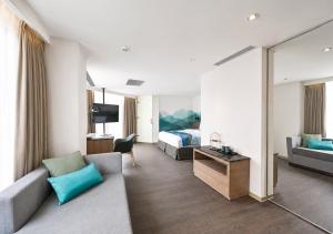 a hotel room with a couch and a bed at Just Sleep Hualien ZhongZheng in Hualien City