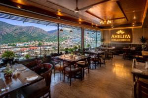 a restaurant with tables and chairs and a view at Hotel Satyaki Orchid in Katra
