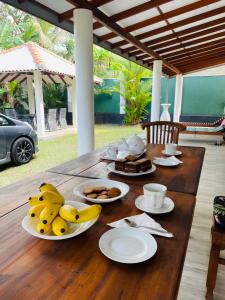 a wooden table with plates of food on it at Mango Villa Bentota in Bentota