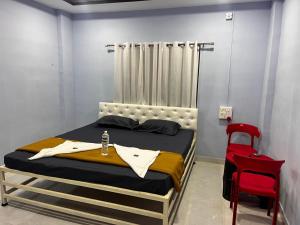 a bedroom with a bed and a red chair at Chairman Lodge in Wanwas Wari