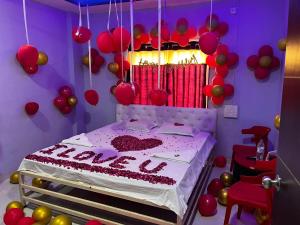 a bedroom with a bed with balloons and a cake at Chairman Lodge in Wanwas Wari
