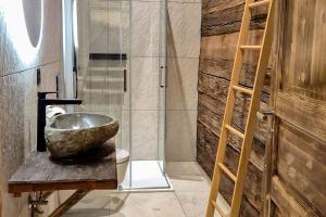 a bathroom with a stone sink and a shower at Chalet Nufenen in Ulrichen +4 photos