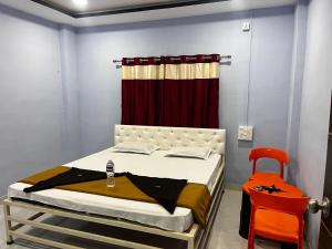 a bedroom with a bed and a red curtain at Chairman Lodge in Wanwas Wari