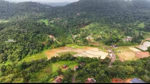 an aerial view of a village on a hill with trees at Ammavvana Kutira Home stay in Madikeri +6 photos