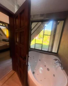 a bath tub in a room with a window at Ćilibar Stara planina in Crni Vrh +50 photos