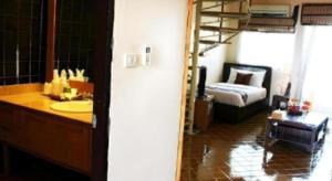 a bathroom with a sink and a bedroom with a bed at Gerard Habitat Hotel in Chiang Mai +101 photos