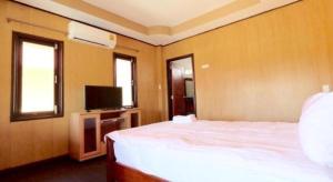 a bedroom with a bed and a tv and two windows at Prakaithong hotel in Amphoe Sawang Daen Din +89 photos