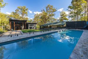 a swimming pool in front of a house at Valley Retreat in Smiths Lake