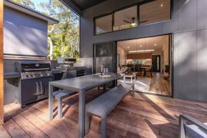 a kitchen and dining room with a table and bench at Valley Retreat in Smiths Lake