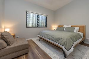 a bedroom with a bed and a couch and a window at Valley Retreat in Smiths Lake +22 photos