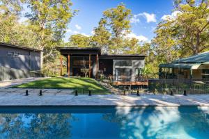a house with a swimming pool in front of a house at Valley Retreat in Smiths Lake