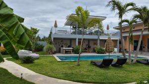 a villa with a swimming pool and a house at Sunset Homestay in Cha Am