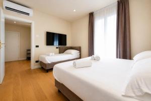 a hotel room with two beds and a flat screen tv at Best Western Hotel Arya in Sirmione