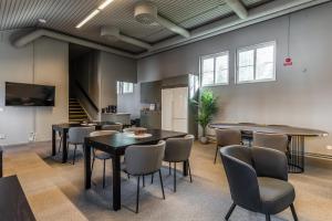 a meeting room with tables and chairs and a staircase at Brunnsvik Hotell & Konferens in Ludvika