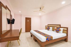 a bedroom with a bed and a desk and a television at FabHotel Vaishanvi Palace in Hyderabad +27 photos