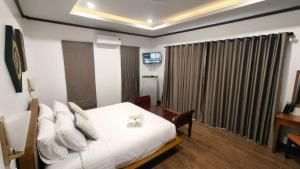 a bedroom with a bed and a table and a window at Ladda Garden Home in Klong Muang Beach +5 photos