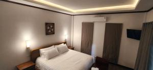 a bedroom with a white bed with two pillows at Ladda Garden Home in Klong Muang Beach