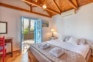 a bedroom with a bed and a desk and a window at Villa Antonia in Almyrida