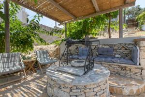 a patio with two chairs and a stone fireplace at Villa Antonia in Almyrida +37 photos