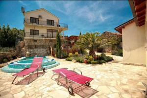 a house with two chairs and a swimming pool at Villa California in Tivat