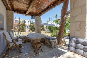 a patio with a stone fireplace and a wooden pergola at Villa Antonia in Almyrida