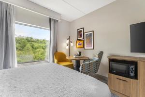 a hotel room with a bed and a tv and a window at Hampton Inn & Suites Pittsburgh-Meadow Lands in Washington