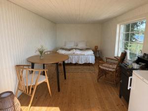 a bedroom with a bed and a table and chairs at Vånga 771 in Örkelsö +24 photos