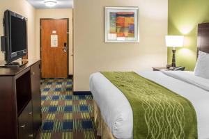 a hotel room with a bed and a flat screen tv at Econo Lodge Ankeny - Des Moines in Ankeny