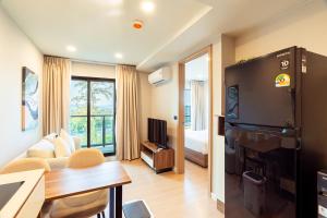 a room with a living room with a tv and a couch at RJ Space in Ban Thalat Choeng Thale