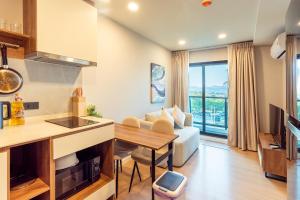 a kitchen and living room with a couch and a table at RJ Space in Ban Thalat Choeng Thale
