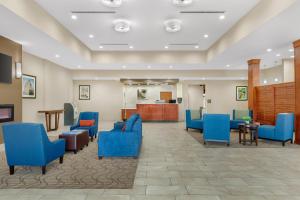 a waiting room at a hospital with blue chairs at Comfort Suites Greensboro-High Point in Greensboro +57 photos