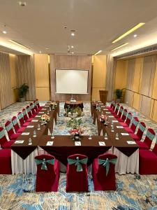 a conference room with long tables and red chairs at Pride Premier Bengaluru in Bangalore