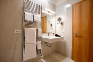 a bathroom with a sink and a shower with towels at Rifugio Palafavera in Val di Zoldo