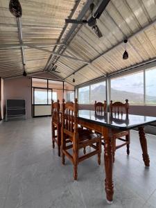 a large room with a table with chairs and windows at VV Guest House & Rooms in Tiruvannāmalai