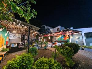 a building with a patio with tables and chairs at night at Hangover Hostels Mirissa in Mirissa
