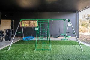 a play room with two swings and a slide at The Landmark in Furano