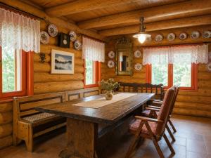 a dining room with a wooden table and chairs at Traditional wooden cottage in Cîmpu Cetăţii