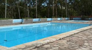 a swimming pool with blue water in a yard at Casa da Paz - Gravatá in Gravatá