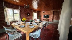 a dining room with a wooden table and chairs at Casa da Paz - Gravatá in Gravatá