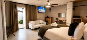 a bedroom with a bed and a chair and a television at 78onJean in Centurion