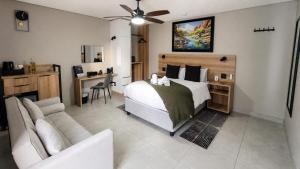 a bedroom with a bed and a couch and a desk at 78onJean in Centurion +131 photos