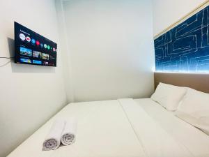 a small room with a bed with a flat screen tv at Cana's Boarding Ciledug in Pasarjumahat-Kulon