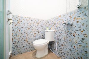 a bathroom with a toilet and a shower at Cana's Boarding Ciledug in Pasarjumahat-Kulon