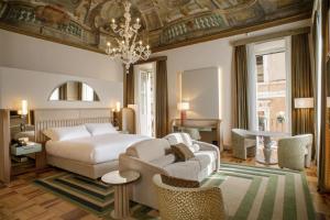 a bedroom with a bed and a couch and a chandelier at Rosetta Hotel Perugia Tapestry Collection By Hilton in Perugia